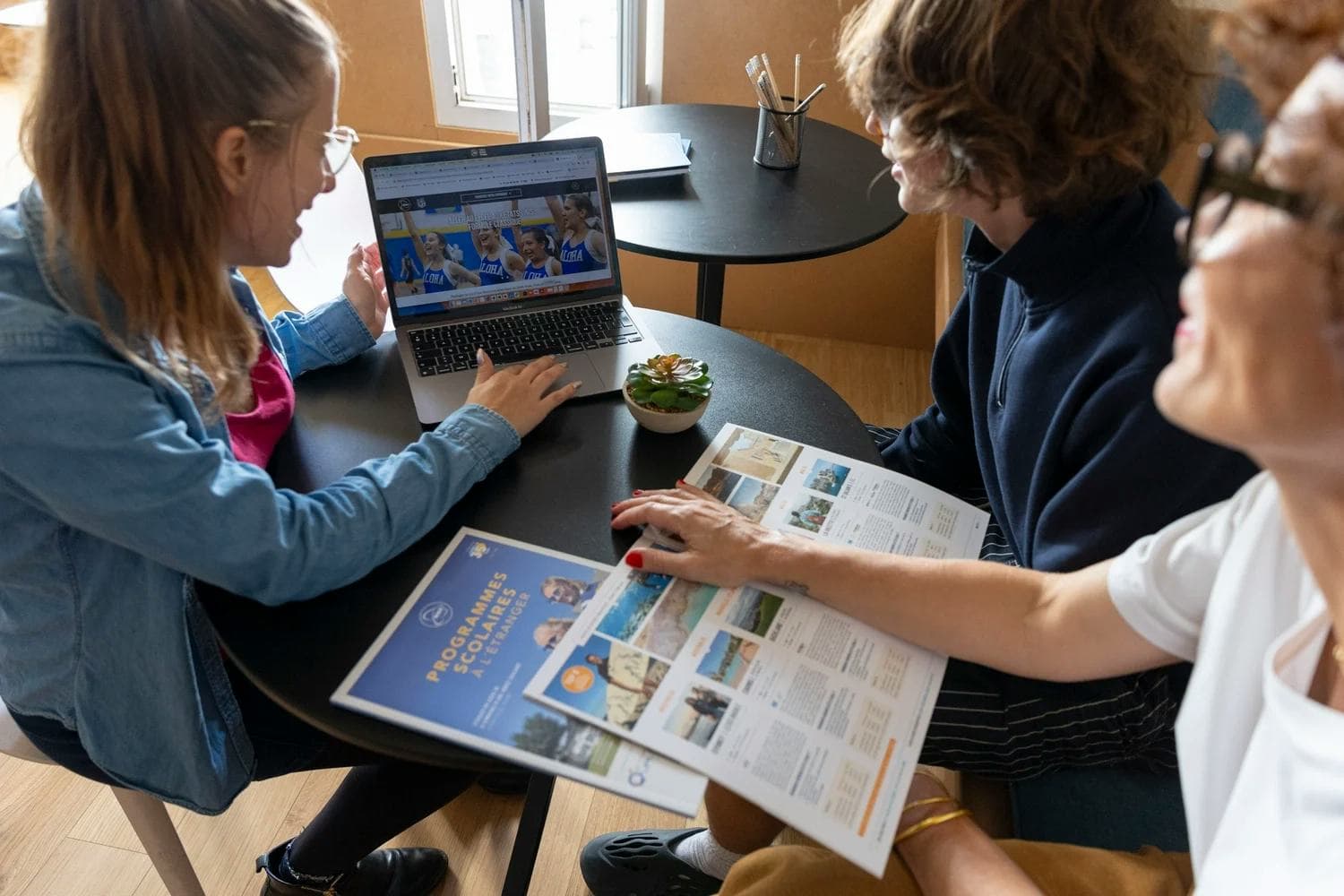 Des élèves consultent du matériel informatif lors d’une séance d’orientation high school, avec accompagnement et conseils personnalisés.